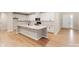 Open kitchen with island, white cabinets, and light hardwood floors at 216 E Warfield Dr, Mooresville, NC 28115
