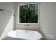 Modern bathroom featuring a freestanding tub and large window at 5318 Cross St, Charlotte, NC 28269