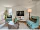 Living area with teal armchairs, geometric coffee table, and hardwood floors at 111 Dorian Pl, Troutman, NC 28166