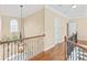 Upstairs hallway with hardwood floors and wrought iron railings at 514 Chase Prairie Ne Ln, Waxhaw, NC 28173