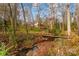 Serene backyard setting with a creek and wooden footbridge at 681 Pine Bluff Cir, Kannapolis, NC 28081