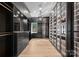 Custom closet with dark cabinetry, glass doors, and chandelier at 13702 Sage Thrasher Ln, Charlotte, NC 28278