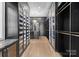 Custom closet with dark cabinetry, glass doors, and chandelier at 13702 Sage Thrasher Ln, Charlotte, NC 28278