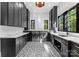 Modern laundry room with dark cabinetry, patterned tile floor, and a sink at 13702 Sage Thrasher Ln, Charlotte, NC 28278