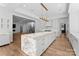 Island kitchen with white cabinets, marble countertops and large island at 13702 Sage Thrasher Ln, Charlotte, NC 28278
