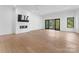 Bright living room with hardwood floors, fireplace, and sliding glass doors leading to a deck at 13702 Sage Thrasher Ln, Charlotte, NC 28278