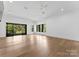 Spacious bedroom with hardwood floors and access to a private balcony overlooking trees at 13702 Sage Thrasher Ln, Charlotte, NC 28278