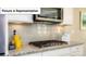 Kitchen detail showing gas cooktop and stylish backsplash at 5084 Silver Creek Ln, Denver, NC 28037