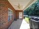 Covered patio with brick flooring, ceiling fan, and access to backyard at 104 Aberdeen Dr, Troutman, NC 28166