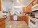 Eat-in kitchen with oak cabinets, white appliances, and a breakfast bar at 104 Aberdeen Dr, Troutman, NC 28166