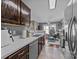 Kitchen with dark wood cabinets, stainless steel appliances and view into home office at 3897 Carl Parmer Dr, Harrisburg, NC 28075