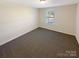 Well-lit bedroom with carpeted floors and a window at 8103 Mossy Rock Rd, Waxhaw, NC 28173