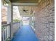 Covered porch with ceiling fan, brick flooring, and white railings at 909 Woodhurst Dr, Monroe, NC 28110