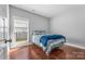 Well-lit bedroom featuring hardwood floors and a window with blinds at 3157 Delaware Dr, Denver, NC 28037