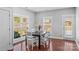 Bright dining area features a dark table with white chairs, hardwood floors and sliding glass door to backyard at 3157 Delaware Dr, Denver, NC 28037