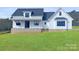 Modern farmhouse exterior with white siding, brick base, and green lawn at 615 Sandycrest Dr, Cherryville, NC 28021