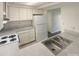 Galley kitchen with white cabinets, stainless steel sink, and electric range at 1831 J Julian Ln # A, Charlotte, NC 28208