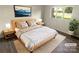 Bright bedroom with a king-size bed, two nightstands, and a window overlooking the backyard at 1831 J Julian Ln # A, Charlotte, NC 28208