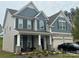Two-story house with gray siding, stone accents, and a two-car garage at 177 Rhuidean Ct, Troutman, NC 28166