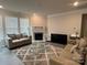 Spacious living room with a fireplace, large windows, and comfortable seating at 177 Rhuidean Ct, Troutman, NC 28166