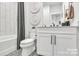 Modern bathroom with white cabinets, a white toilet, and gray patterned floor at 3606 S Tryon St # 16, Charlotte, NC 28217