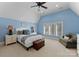 Blue bedroom with a ceiling fan, windows, and comfortable furniture at 18528 Nantz Rd, Cornelius, NC 28031