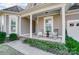 Inviting front porch with rocking chairs, brick steps, and lush landscaping at 5021 Henshaw Rd, Waxhaw, NC 28173