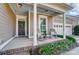 Charming front porch with rocking chairs, white columns, and a dark-colored front door at 5021 Henshaw Rd, Waxhaw, NC 28173