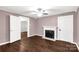 Bedroom featuring mauve walls, a fireplace with a white mantel, wood-look floors, and two doorways at 139 Ebenezer Ave, Rock Hill, SC 29730