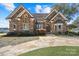 Stone house exterior with a landscaped yard and stone driveway at 18212 Pompano Pl, Cornelius, NC 28031