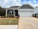 New home exterior features gray siding, stone accents, and a two-car garage at 1044 Bull Dog Ln, Wingate, NC 28174