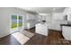 Modern kitchen with white cabinets, an island, and dark hardwood floors at 9305 Ketchum Dr, Gastonia, NC 28056