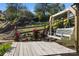 Wooden deck with a swing, stairs, and lush landscaping at 309 Commodore Loop, Mooresville, NC 28117