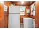 View of kitchen with white appliances and wood paneled walls at 710 Wood St, Statesville, NC 28677