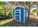 Blue storage shed with white trim in the backyard at 710 Wood St, Statesville, NC 28677