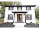 Two story home with white brick, black shutters and modern entryway at 8946 Glencroft Rd, Mint Hill, NC 28227