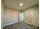 Well-lit bedroom with wood-look floors and access to hallway at 1712 Mcdonald St, Charlotte, NC 28216