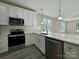 Modern kitchen with stainless steel appliances and white cabinets at 1712 Mcdonald St, Charlotte, NC 28216