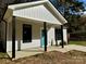 Newly built home with gray siding, teal door, and covered porch with black support posts at 1712 Mcdonald St, Charlotte, NC 28216