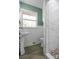 Updated bathroom with pedestal sink, marble shower, and wood-look tile floor at 615 E Ridge St, Kings Mountain, NC 28086