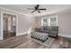 Living room boasts hardwood floors, a gray sofa and ottoman, and a ceiling fan at 807 Klondale Ave, Kannapolis, NC 28081