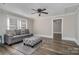 Living room with gray sofa, ottoman, ceiling fan, and hardwood floors at 807 Klondale Ave, Kannapolis, NC 28081