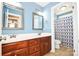 Double vanity bathroom with wood cabinets and blue walls at 4108 Cheshire Glen Dr, Monroe, NC 28110