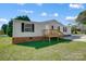 Front view of a manufactured home with brick skirt and deck at 1363 Shinnville Rd, Cleveland, NC 27013