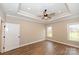 Bright bedroom with tray ceiling, ceiling fan, wood-look floors, and large window at 4916 Southview Dr, Hickory, NC 28602