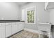 Bright laundry room, featuring white cabinets, granite countertops, and a utility sink at 7754 Long Bay Pkwy, Catawba, NC 28609