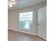 Spacious bedroom with large window, ceiling fan, and wood-look flooring at 4605 Coronado Dr # M, Charlotte, NC 28212