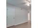 Simple bedroom with wood-look flooring, white walls, and a door at 4605 Coronado Dr # M, Charlotte, NC 28212