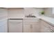 Clean galley kitchen, white cabinets, stainless steel sink, dishwasher at 4605 Coronado Dr # M, Charlotte, NC 28212