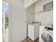 Bright laundry room with washer, dryer, and built-in shelving at 2033 Twilight Ln, Monroe, NC 28110